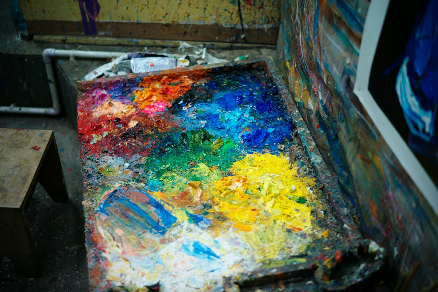 Tavolozza da pittore in legno coperta di colori a olio densi e vivaci.